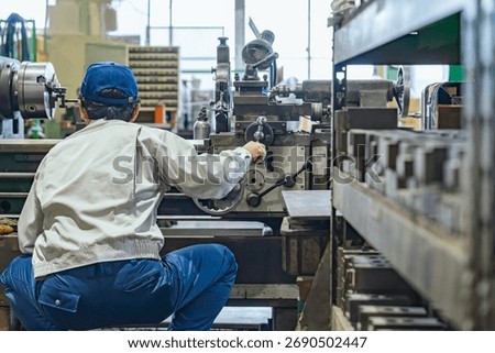 A group of workers operating machine tools in a factory