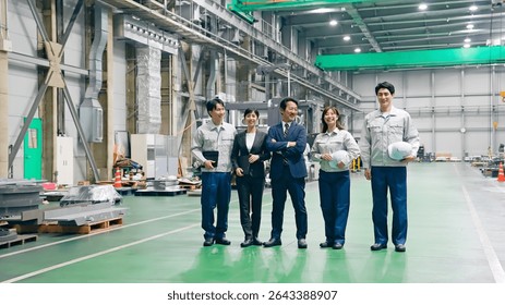 A group of workers standing side by side in a factory