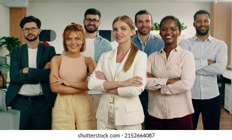 A Group Of Workers Are Staring Directly At The Camera While Having Their Arms Folded And Standing In A Formation With A Beautiful Woman In The Front