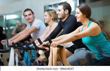 Group working out of cycling in modern fitness club. Selective focus