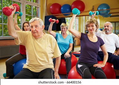 Group Working Out With Dumbbells In Gym