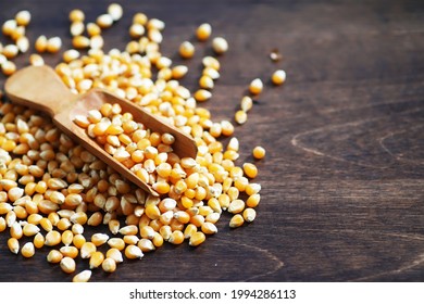 Group of yellow raw corn kernels sweet corn. Grain seeds ingredient golden maize kernel. Wooden table ripe popcorn background.