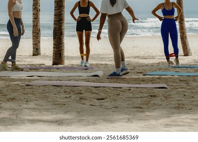 Group yoga session on a beach with young female adults. Outdoor activities, exercise on beach - Powered by Shutterstock