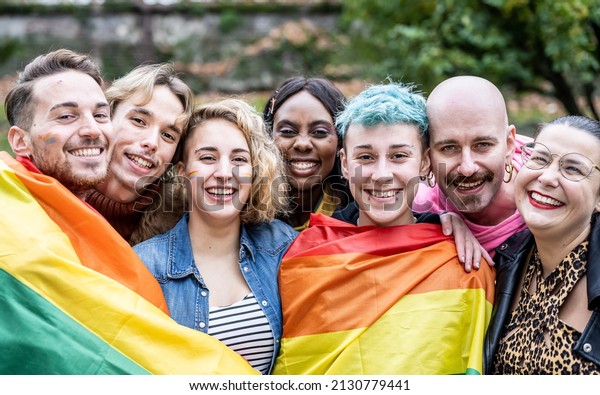 Group of young activist for\
lgbt rights with rainbow flag, diverse people of gay and lesbian\
community