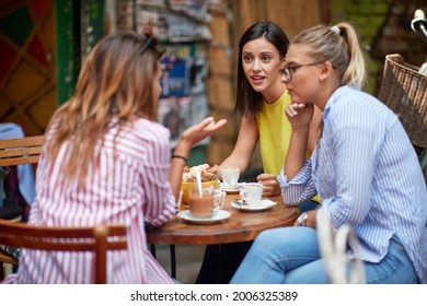 Group Of Young Adult Caucasian Female Friends Talking, Sitting In Outdoor Cafe, Drinking Coffee. Serious Talk, Conversation