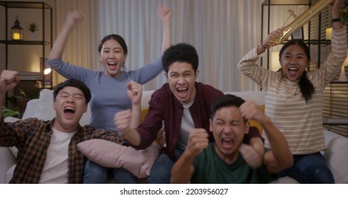 Group of young adult friend man and woman asia people sit at sofa couch joy night party fun game FIFA world cup live TV at home eat snack bowl drink beer bottle glass jump mad happy win exult face. - Powered by Shutterstock