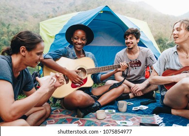 Group Of Young Adult Friends In Camp Site Playing Guitar And Ukelele And Singing Together Outdoors Recreational Leisure And Friendship Concept