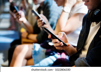Group of young adult friends using smartphones in the subway - Shutterstock ID 1022806330