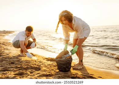 Group of young adults cleaning up plastic waste on a sunny beach during the day, promoting environmental awareness and sustainability efforts. The concept of conservation of ecology. Earth - Powered by Shutterstock