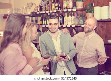 Group Of Young Adults Hanging Out In Bar With Drinks. Selective Focus
