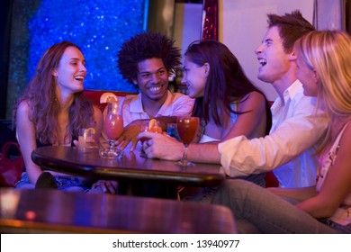 Group Of Young Adults In A Nightclub Talking And Laughing