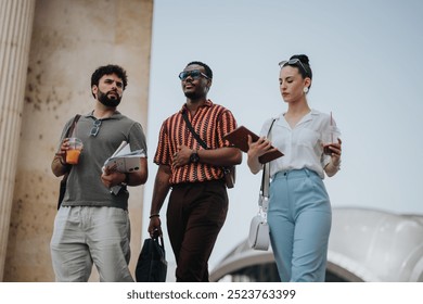 Group of young adults strolling outdoors, holding beverages and notebooks, engaged in conversation and study. - Powered by Shutterstock