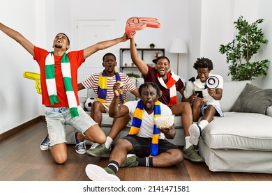 Group of young african american friends watching and supporting soccer match at home. - Shutterstock ID 2141471581