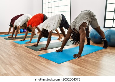 Group Of Young African American Man Training Yoga At Sport Center.