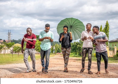 Group Of Young African Friends, Walking Together, Laughing, Having Fun, Using Their Mobile Phones