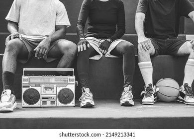 Group of young african people listening music outdoor after basketball match - Focus on boombox stereo - Black and white editing - Powered by Shutterstock