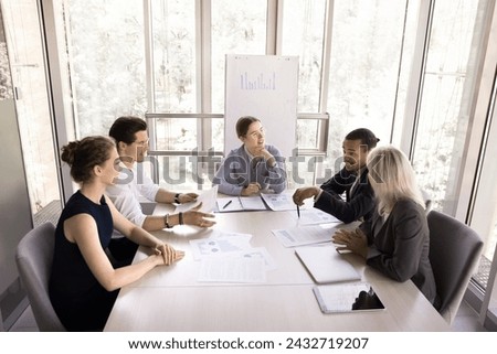 Group of young ambitious office employees, business partners, staff members gathered together in modern conference room to share opinion, review sales stats results, take part in briefing or seminar 商業照片 © 