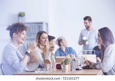 Group Of Young Ambitious Workers Eating Their Lunch At The Office