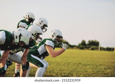 Group of young American football players going over offensive drills on a sports field during a team practice  - Shutterstock ID 2152231959