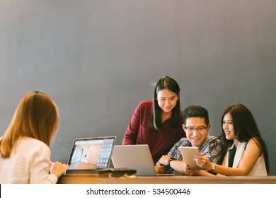 Group Of Young Asian Business Colleagues In Team Casual Discussion, Startup Project Business Meeting Or Happy Teamwork Brainstorm Concept, With Copy Space, Depth Of Field Effect