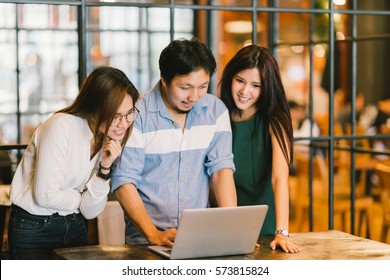 Group Of Young Asian Business Colleagues In Team Casual Discussion, Startup Project Business Meeting Or Happy Teamwork Brainstorm Concept, With Copy Space, Depth Of Field Effect, Focus On The Man.