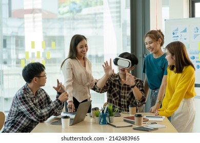 Group Of Young Asian Business People Using Virtual Reality Glasses During Meeting Testing Virtual Reality Headset And Exchange Project Ideas Shared To Improve The Visual Experience.