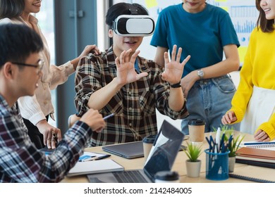 Group Of Young Asian Business People Using Virtual Reality Glasses During Meeting Testing Virtual Reality Headset And Exchange Project Ideas Shared To Improve The Visual Experience.