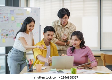 Group of young Asian business people brainstorming, looking at laptop computer. - Shutterstock ID 2146938387