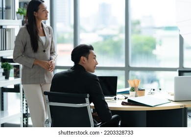 A Group Of Young Asian Entrepreneurs. Meeting To Review Stock Investment Data In A Meeting Room With Natural Light Windows.