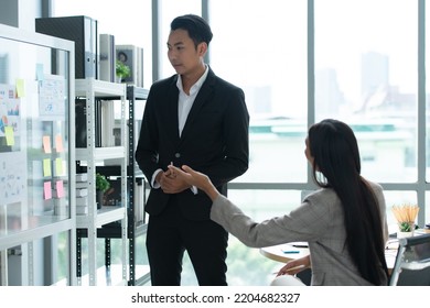 A Group Of Young Asian Entrepreneurs. Meeting To Review Stock Investment Data In A Meeting Room With Natural Light Windows.