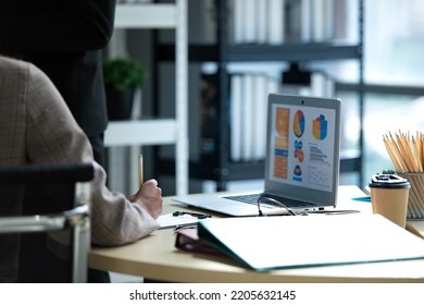 A Group Of Young Asian Entrepreneurs. Meeting To Review Stock Investment Data In A Meeting Room With Natural Light Windows.