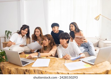 Group of Young Asian man and woman university college students using laptop computer and tablet for research study brainstorming discussion analyze ideas making project report together in living room. - Powered by Shutterstock