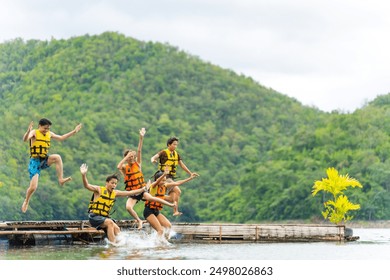 Group of Young Asian man and woman enjoy and fun outdoor lifestyle travel nature lake house on summer holiday vacation. Happy people friends with life vest jumping into the lake and swimming together. - Powered by Shutterstock