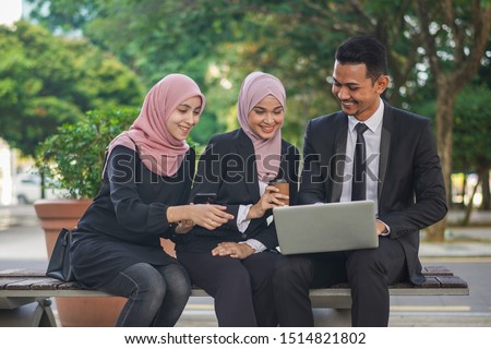 Group of young Asian Muslim corporate makin an online reservation for business trip