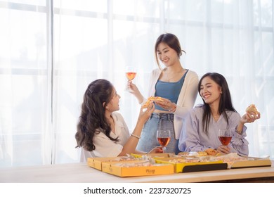 Group of young asian office girl friends having fun and celebrating pizza on table during party - Powered by Shutterstock