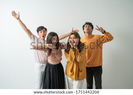 group of young Asian people happy to celebrate when looking at the camera with an isolated background