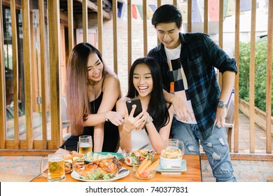 Group Of Young Asian People Party Celebration In 
Restaurant And And Enjoy With Phone.