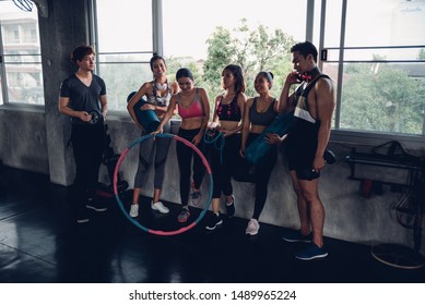 Group Of Young Asian People In Sportswear Talking After A Workout In Gym