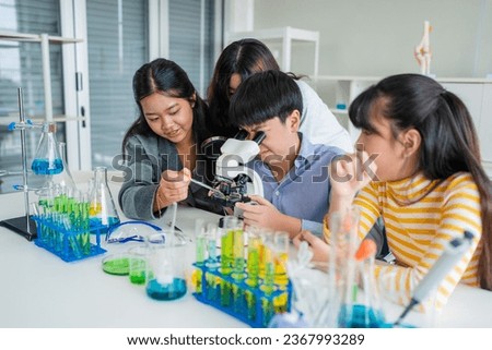 Group of young asian schoolgirls learning research and doing experiment in chemistry classroom. Fun study back to school concept.