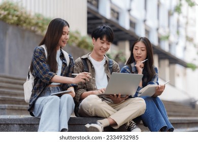 Group Of Young Asian Students Collaborating Outdoors at University. Teamwork and Knowledge Sharing. Asian Students Engaged in Collaborative Learning Outdoors. - Powered by Shutterstock