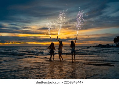 Group of Young Asian woman friends dancing and playing sparklers firework together at tropical beach in summer night. Happy girl enjoy and fun outdoor lifestyle nightlife party on holiday vacation. - Shutterstock ID 2258848447