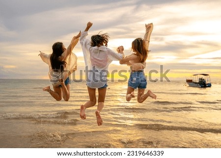 Group of Young Asian woman friends walking and playing together in the sea at tropical island beach at summer sunset. Attractive girl enjoy and fun outdoor lifestyle travel nature on holiday vacation.