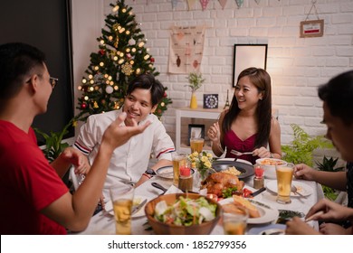 Group Of Young Asians Having A Party At Home. They Are Eating And Drinking Beer While Talking.