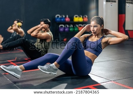 Group of young athlete male and female exercising together in fitness. Attractive handsome sportsman and sportswomen doing sit-up cardio workout to maintain strong muscle for health care in gym club.