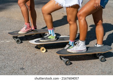 Group Of Young Beautiful Asian Woman Skateboarding Together At Skate Park On Summer Vacation. Happy Active Female Friends Enjoy Outdoor Activity Lifestyle And Extreme Sport Surf Skate At Public Park.