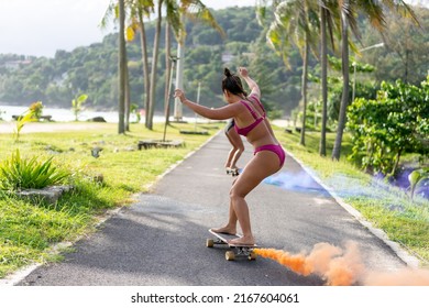 Group Of Young Beautiful Asian Woman Skateboarding Together At Skate Park On Summer Vacation. Happy Active Female Friends Enjoy Outdoor Activity Lifestyle And Extreme Sport Surf Skate At Public Park.