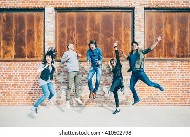 Group of young beautiful multiethnic man and woman friends having fun jumping outdoor in the city - happiness, friendship, teamwork concept 