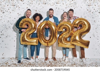 Group of young beautiful people in casual clothing carrying gold colored numbers and smiling - Shutterstock ID 2058719045