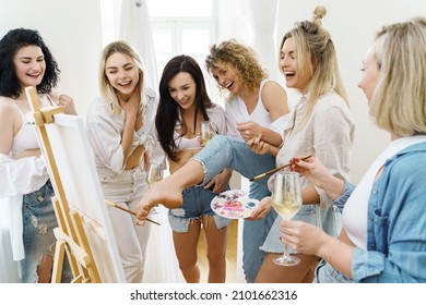 Group Of Young Beautiful Women Paint On Canvas And Drinking White Wine During Party At Home