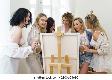 Group Of Young Beautiful Women Paint On Canvas And Drinking White Wine During Party At Home